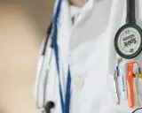 Lekarz w białym fartuchu ze stetoskopem i przyborami w kieszeni. Wczesne wykrycie chlamydii u mężczyzn jest kluczowe dla zdrowia.