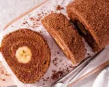 Pyszna rolada biszkoptowa z bananem w środku, posypana kakaową posypką. Idealna na deser.