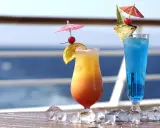Due cocktail colorati, un tramonto e un blu intenso, decorati con ombrellini e frutta, perfetti per godersi i pacchetti bevande MSC in crociera.