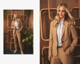 Elegancka stylizacja: jakie spodnie do jasnej marynarki? Modelka prezentuje beżowy garnitur z błękitną koszulą i sneakersami.