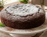 Torta all'acqua al cacao, soffice e golosa, spolverata di zucchero a velo e decorata con menta fresca.