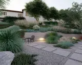 Un giardino moderno con ghiaia, piante succulente e graminacee. Idee originali per un giardino con ghiaia, con un piccolo tavolo e sedie per godersi la tranquillità.