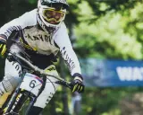Downhill-Fahrer Mark Wallace in voller Fahrt, mit Helm und Brille, bereit für die nächste Herausforderung.