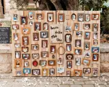 Un original seating plan boda con muchas fotos de parejas en marcos de madera.