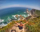 Frau genießt die atemberaubende Lissabon Natur am Cabo da Roca. Türkises Meer, Felsen und üppige Vegetation.