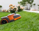 Un robot tondeuse autonome sur une pelouse verte, montrant comment fonctionne un robot tondeuse pour un jardin impeccable.