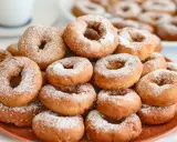 Montón de rosquillas caseras esponjosas espolvoreadas con azúcar glas.