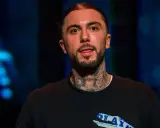 Malik Montana, mój brat, z tatuażami na szyi, w czarnej bluzie z napisem "PLAY".