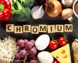 Słowa "CHROM" na drewnianych klockach otoczone przez produkty bogate w ten pierwiastek: papryka, brokuły, cebula, jajka, winogrona, owies, ser, pomidory, grzyby, chleb i proszek.