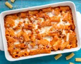 Un invitante piatto di pasta al forno con sugo rosso e formaggio filante, pronto per essere gustato.