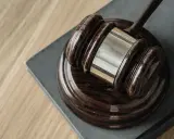 Młotek sędziowski na księdze symbolizuje rygor egzekucji umowy najmu.