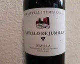 Flaschenetikett für Castillo de Jumilla Wein, mit Monastrell und Tempranillo Trauben. Ein Schloss-Symbol ziert das Etikett.