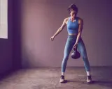 Frau trainiert mit Kettlebell, Teil der 75 Hard Challenge.