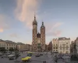 Majestatyczna Bazylika Mariacka góruje nad Rynkiem Głównym w Krakowie. Tłumy spacerują, podziwiając architekturę i atmosferę miasta.