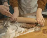 Mains farinées étalant une pâte à biscuits. Une question se pose : par quoi remplacer la farine de sarrasin pour une recette sans gluten ?