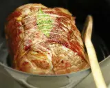 Un rôti de porc cocotte, doré et savoureux, est prêt à être dégusté. Une feuille de laurier orne sa surface.