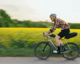 Man cyklar genom ett fält med gula blommor, en idyllisk vy över cykelleder Sverige.