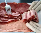 Talerz z wędlinami: salami, szynka, kiełbasa. Jak przechowywać wędlinę w lodówce? Najlepiej w szczelnym pojemniku.