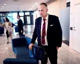 Man i kostym med portfölj, kanske på väg till ett möte. Hans blick ger intryck av att han läst solifokus recensioner.