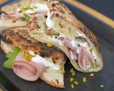 Gegrillte Pizza-Taschen gefüllt mit cremiger Ricotta, Mortadella und Pistazien.