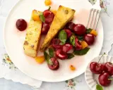 Zwei Scheiben süßer Auflauf mit frischen Kirschen und Aprikosenstücken. Ein köstliches Dessert, das Lust auf mehr Kirschen Rezepte macht.