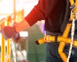 Persona con arnés de seguridad naranja, listo para trabajar en altura. Es crucial revisar la fecha caducidad arnés de seguridad para garantizar la protección.