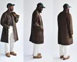 A man models three views of a stylish brown tweed coat, paired with white pants and a green cap.