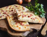 Flammekueche, une spécialité alsacienne d'origine, garnie de lardons et d'oignons sur une pâte fine.