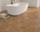 Bagno moderno con vasca freestanding e pavimento in parquet geometrico. Idee bagno con parquet per un tocco di calore e design.