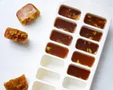 Eiswürfelbehälter mit gefrorener Brühe und Gewürzen. So kann man einfach Suppe einfrieren und später verwenden.