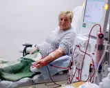 Kobieta podłączona do dializy przez cewnik dializacyjny. Maszyna do dializy monitoruje jej stan.