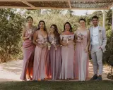 Grupo de damas de honor y el novio posando para una foto en una boda informal campo.