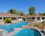 La piscina e il giardino di una casa che ricorda lo stile del **Kim Kardashian house**, con un'architettura moderna e un'area esterna rilassante.