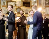 Elegancka para tańczy, czar wódki unosi się w powietrzu. W tle inni goście bawią się na balu.