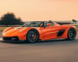 Ein orangefarbener Jesko von Koenigsegg rast auf einer Straße.