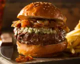 Jugosa hamburguesa con queso de cabra desmenuzado, cebolla caramelizada y papas fritas crujientes.