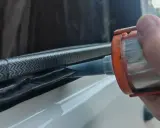 Application de mastic Sika 265 sur un joint de fenêtre de véhicule pour une étanchéité parfaite.