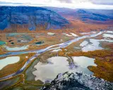 Vacker höstfärgad vy över Kungsleden, med slingrande vattendrag och fjäll. Perfekt tid att vandra.