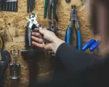 Ręka sięga po narzędzia, zastanawiając się, jakie klucze do roweru będą potrzebne do naprawy.