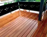 Terrasse privative en copropriété avec un plancher en bois brillant et des panneaux décorés de silhouettes d'oiseaux.