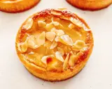 Un délicieux gâteau poire amandine, doré et garni d'amandes effilées, prêt à être dégusté.