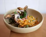 Poisson frit croustillant avec salade de carottes râpées et oignons rouges, une spécialité du restaurant la joie.
