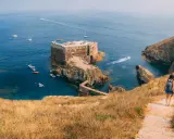Wanderin auf der Insel Berlenga Grande, Portugal, Leiria. Eine Festung thront im Meer, Boote schaukeln im Wasser.