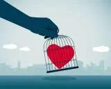 Mano che tiene una gabbia con un cuore rosso dentro, simbolo di esempi di manipolazione emotiva.