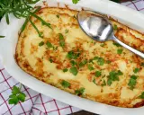 En gyllene omelett i ugn, toppad med färsk persilja och en sked redo att servera. Perfekt för en mysig frukost eller lätt lunch.