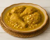 Pollo en pepitoria, un plato tradicional español, servido en un cuenco de cerámica con trozos de huevo duro y hebras de azafrán.