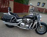 Błyszczący, czarny motocykl Honda VTX 1300 z sakwami i oparciem. Dane techniczne tego klasyka są imponujące.