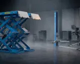 Dos tipos de elevadores para taller: uno de tijera azul y otro de dos columnas azul.