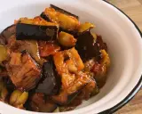 Un plato de caponata siciliana, con berenjenas, aceitunas y tomate, servido en un cuenco blanco.