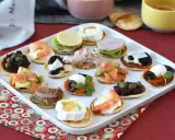 Plateau de blinis garnis de crevettes, saumon, fromage de chèvre, tapenade, jambon et autres délices.